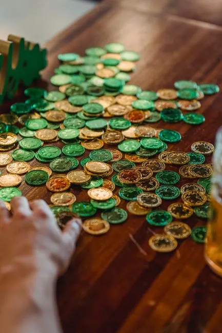 Neatly organized craft supplies with green, gold, and rainbow colors on a wooden table, ready for St